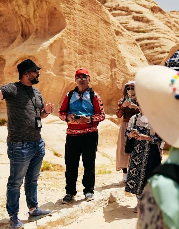 Travel guide explaining desert tour to tourists in rocky landscape India