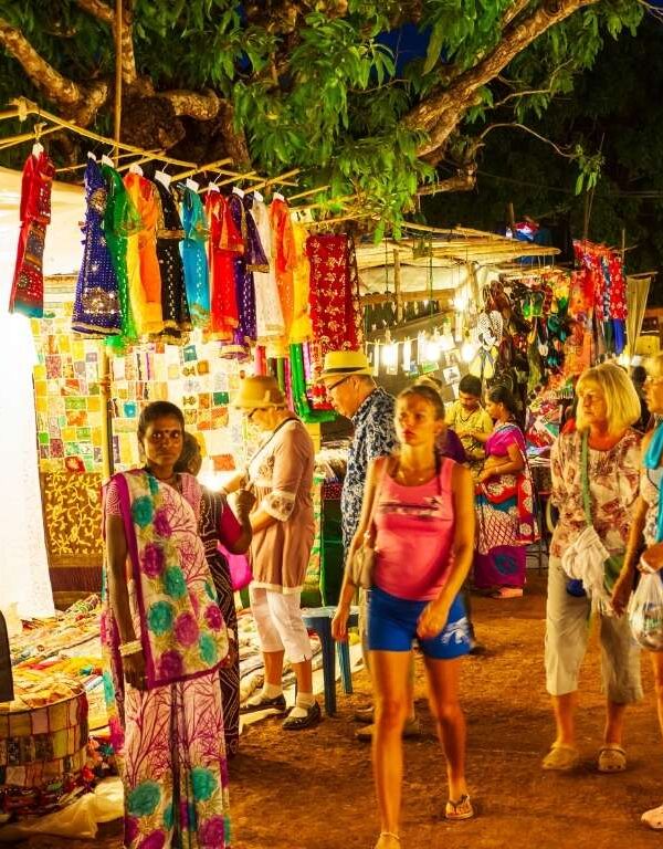Families and tourists shopping at a colorful night market in India