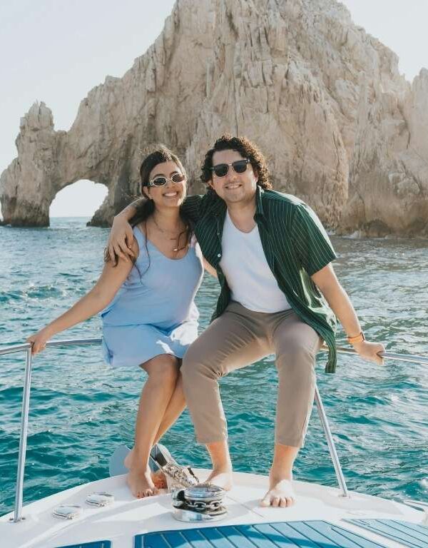 Couple enjoying a luxury yacht trip on blue sea near rocky coastline
